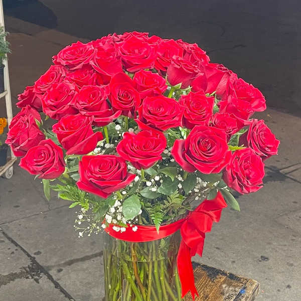 Bouquet of red roses in a clear glass vase with a red ribbon
