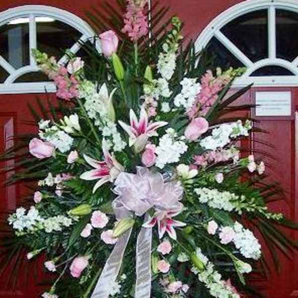 Large pink and white funeral spray with lilies and ribbon