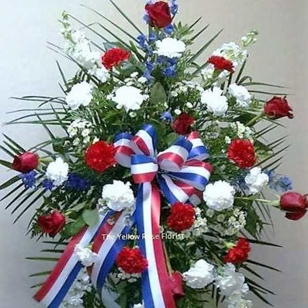 Standing floral spray with red, white, and blue flowers and ribbon