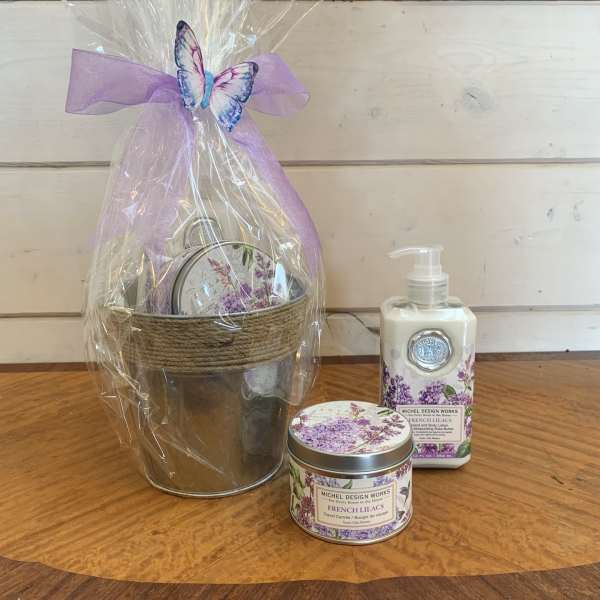 Gift basket with lilac-scented lotion and candle in a wrapped metal pail