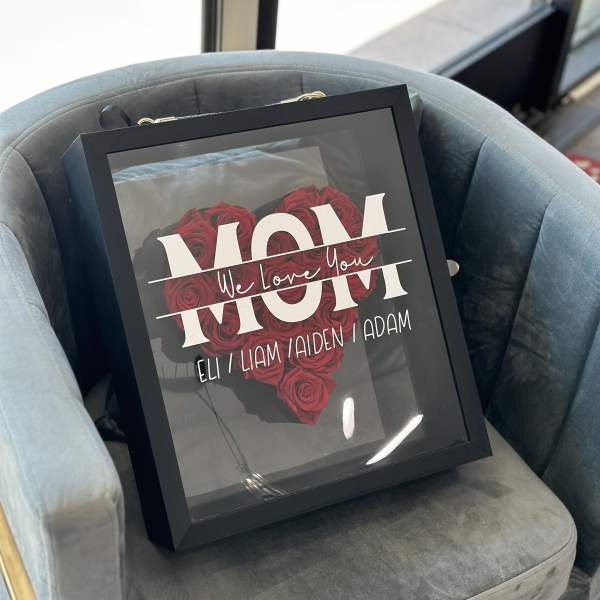 Framed arrangement of red roses with a "Mom" message
