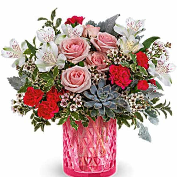 Pink and red roses with white alstroemeria in a pink glass vase