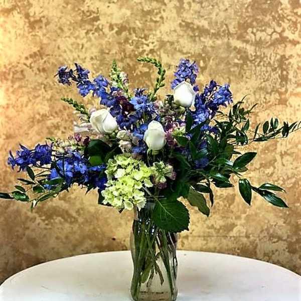 Blue and white mixed bouquet in a clear glass vase