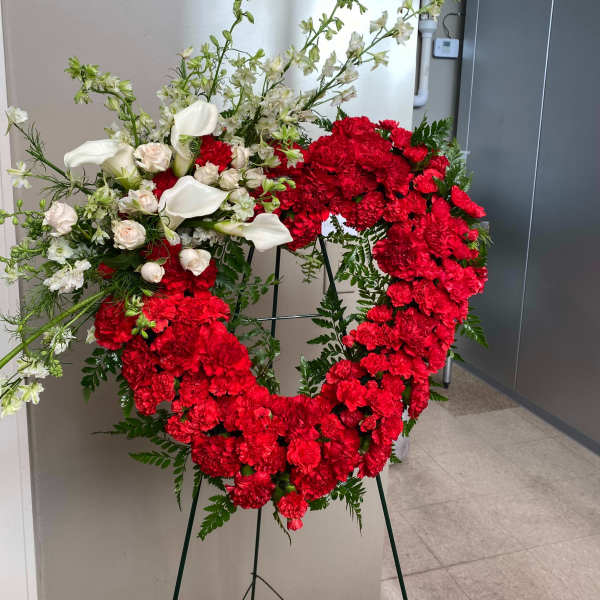 Large red and white floral wreath on a stand