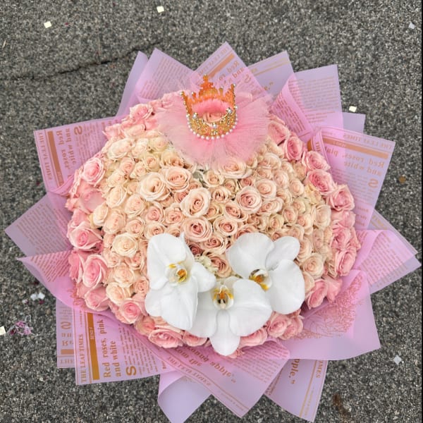 Pink rose bouquet with white orchids and a small crown topper