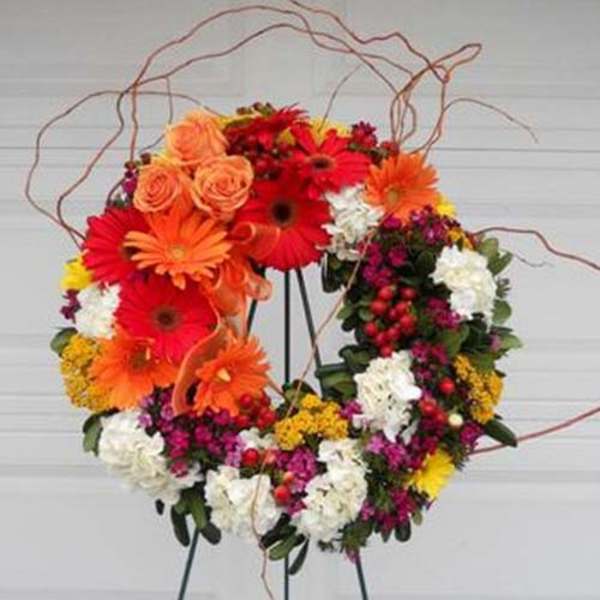 Heart-shaped floral wreath with orange, red, white, and yellow blooms