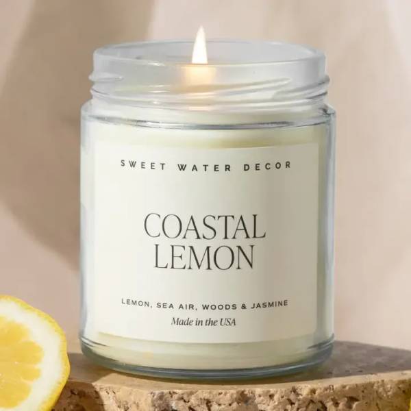 Lit lemon-scented candle in a clear glass jar