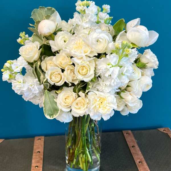 White roses and ranunculus in a clear glass vase