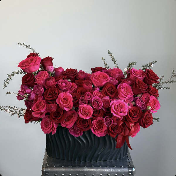 Large bouquet of pink and red roses in a dark vase