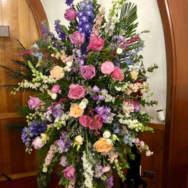 Large standing floral spray with pink, purple, and white flowers