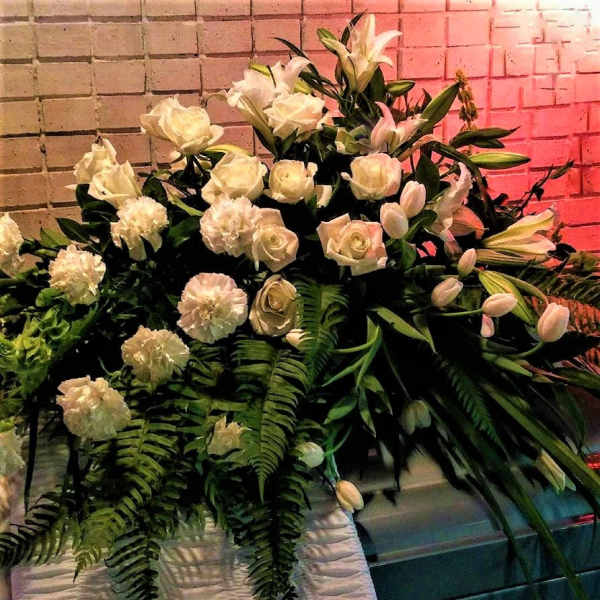 Large white floral arrangement with roses, lilies, and carnations