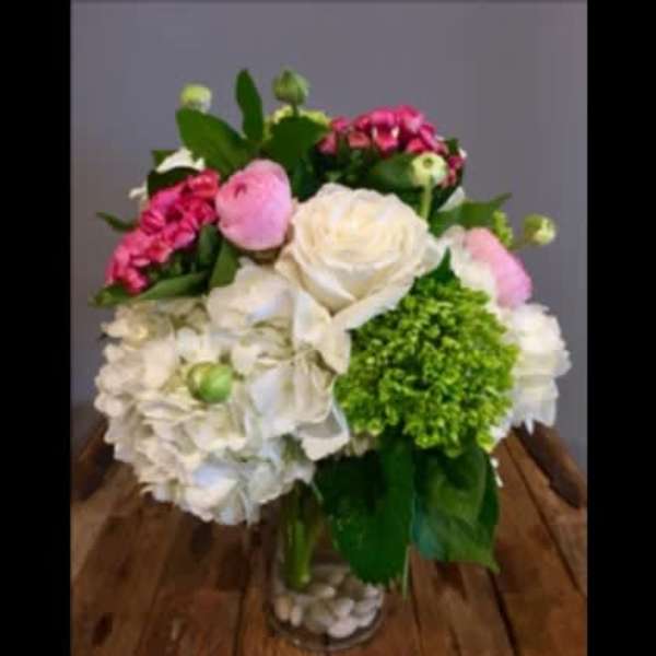 Bouquet of white, pink, and green flowers in a clear glass vase