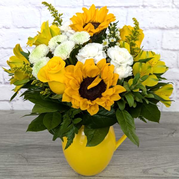 Yellow and white bouquet in a yellow pitcher vase