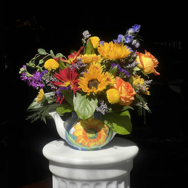 Bright mixed bouquet in a painted ceramic pitcher