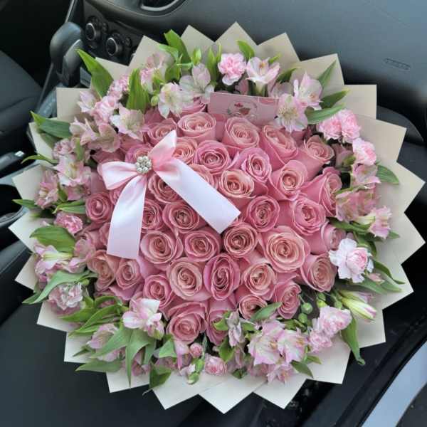 Pink rose bouquet with a white ribbon and small pink flowers