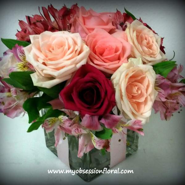 Bouquet of pink and peach roses in a glass vase