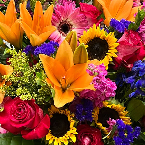 Bright mixed bouquet with orange lilies, sunflowers, and pink roses
