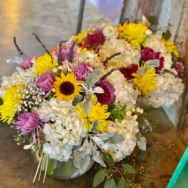 Mixed bouquet with sunflowers, chrysanthemums, and white hydrangeas in a vase