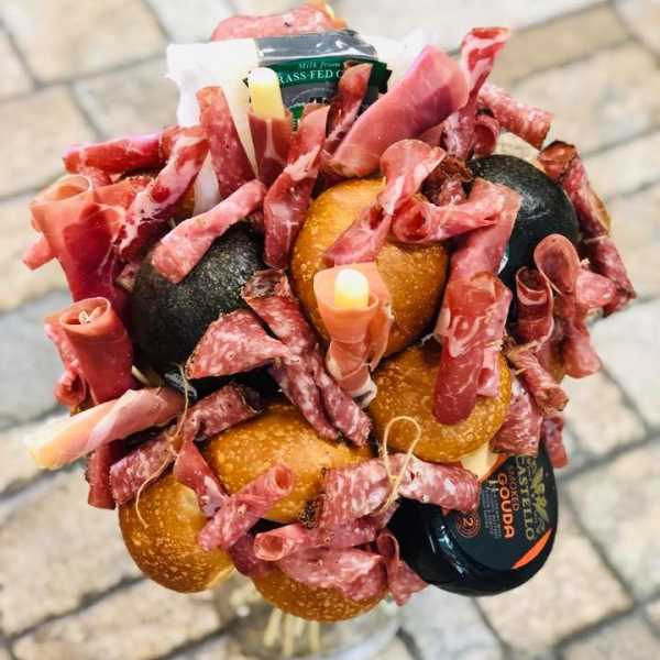 Bouquet made of cured meats and cheese in a clear vase