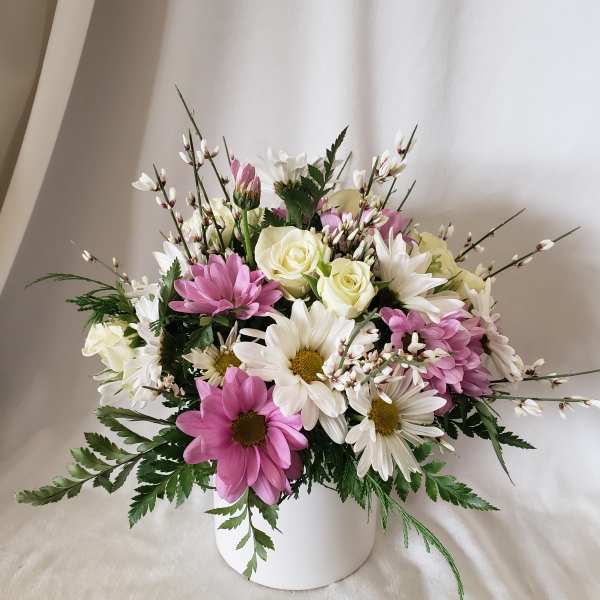 Pink and white daisy bouquet in a white vase