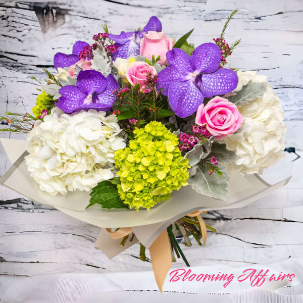Bouquet of purple orchids, pink roses, white hydrangeas, and green blooms