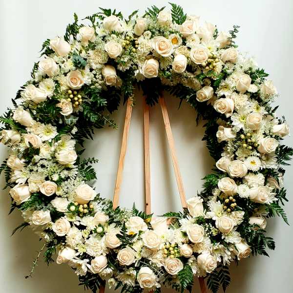 Large white floral wreath on a wooden easel