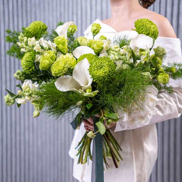 Bride holding a white and green bouquet with calla lilies and chrysanthemums