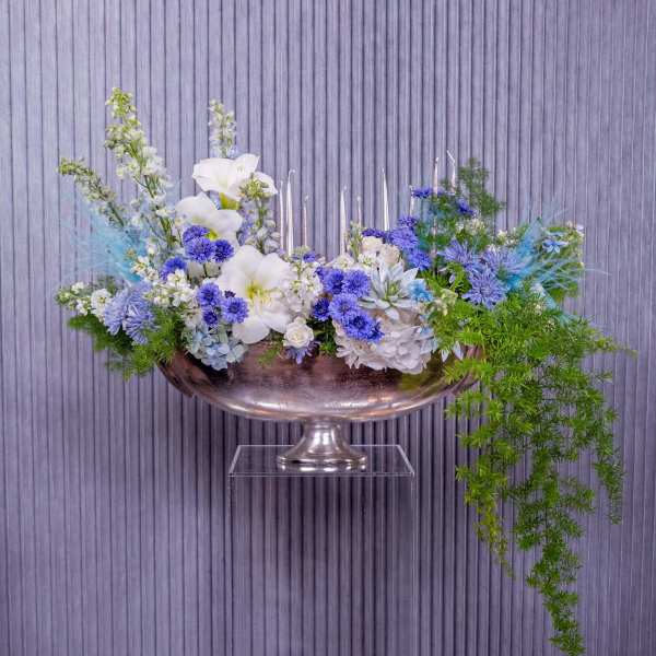 Blue and white floral arrangement in a silver pedestal bowl