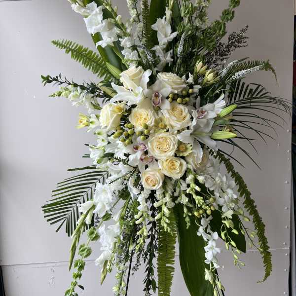 Tall white floral standing spray with roses and orchids