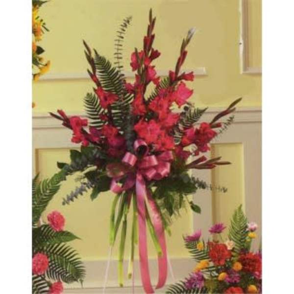 Tall red floral arrangement with a pink ribbon bow