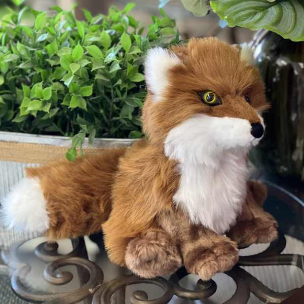 Plush fox beside a potted plant and pale hydrangeas