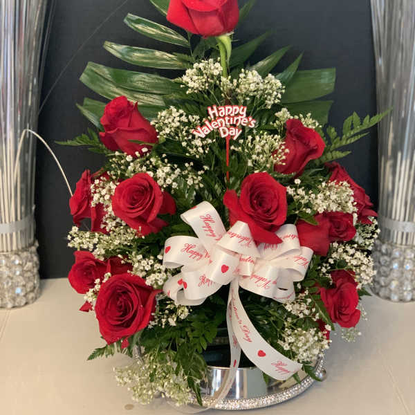 Red roses arranged with baby's breath and a Valentine ribbon