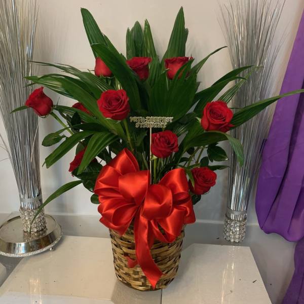 Red roses in a woven basket with a large red bow
