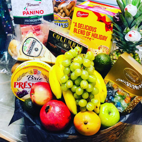 Gift basket with fruit, cheese, chocolates, and a pineapple centerpiece