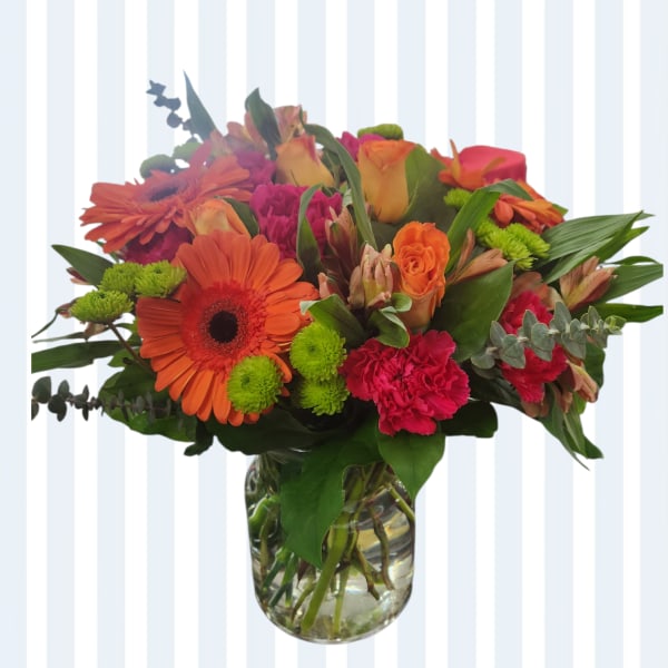 Bouquet of orange and pink flowers in a clear glass vase