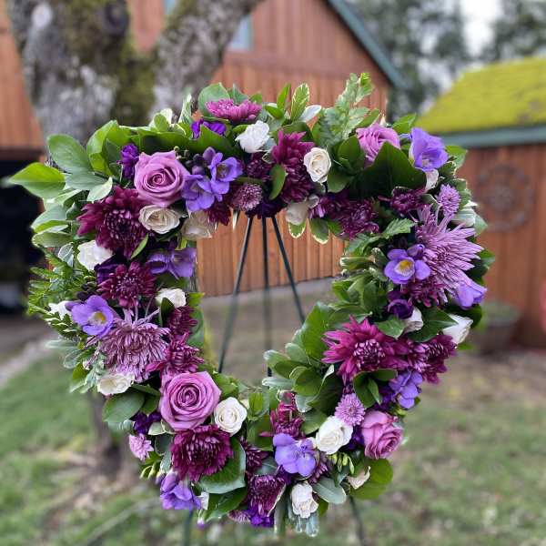 Heart-shaped floral wreath with purple and white blooms