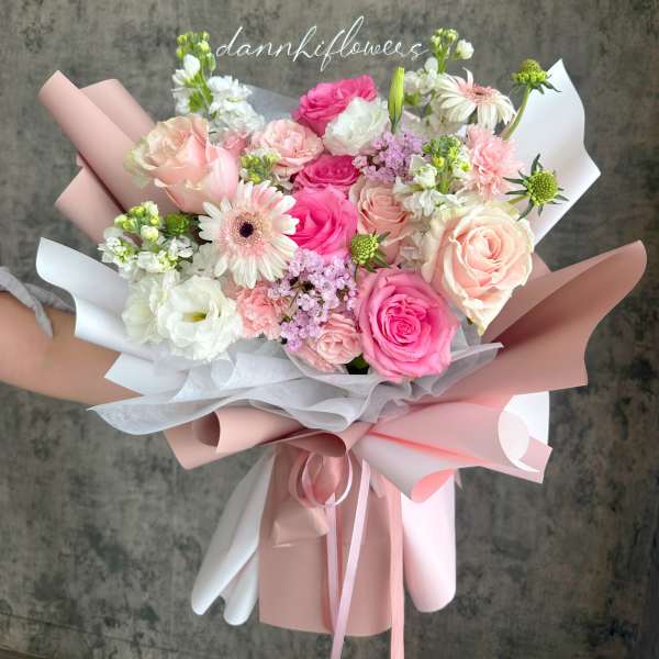Hand-tied bouquet of pink and white roses with gerbera daisies
