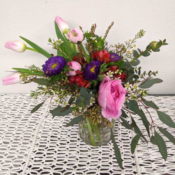 Pink and purple mixed bouquet in a clear glass vase