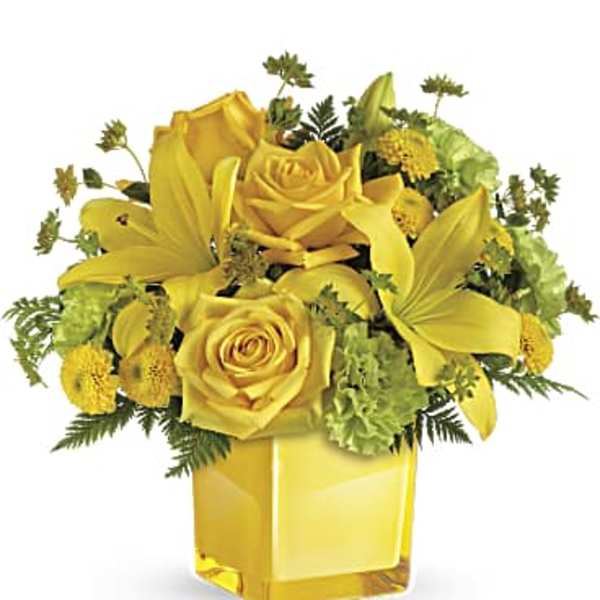Yellow roses and lilies arranged in a square glass vase