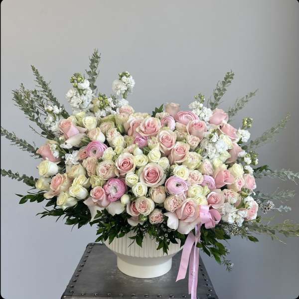 Large bouquet of pink and white roses in a white vase