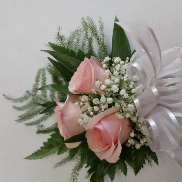 Pink roses with baby's breath and a white ribbon bow
