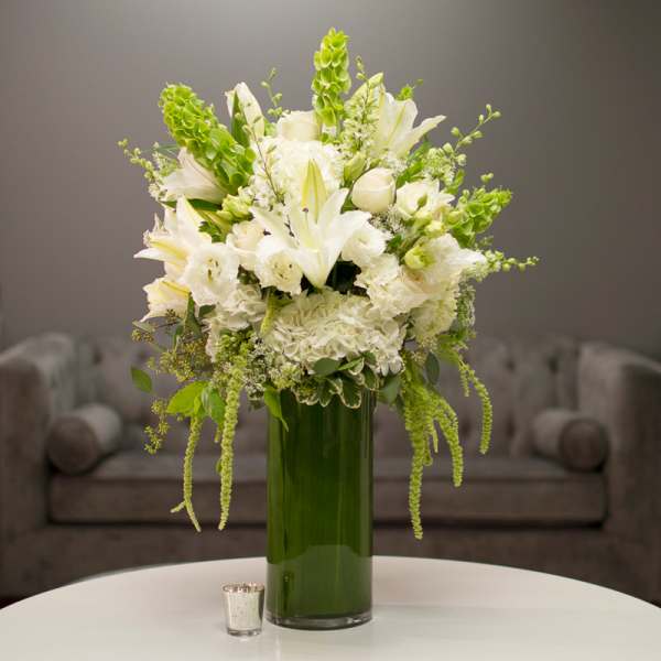 White floral arrangement in a tall green vase