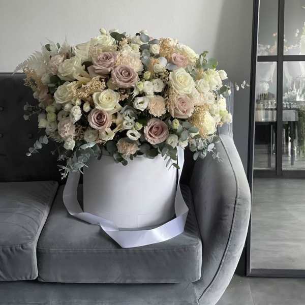 Large pastel flower arrangement in a white hatbox with a ribbon