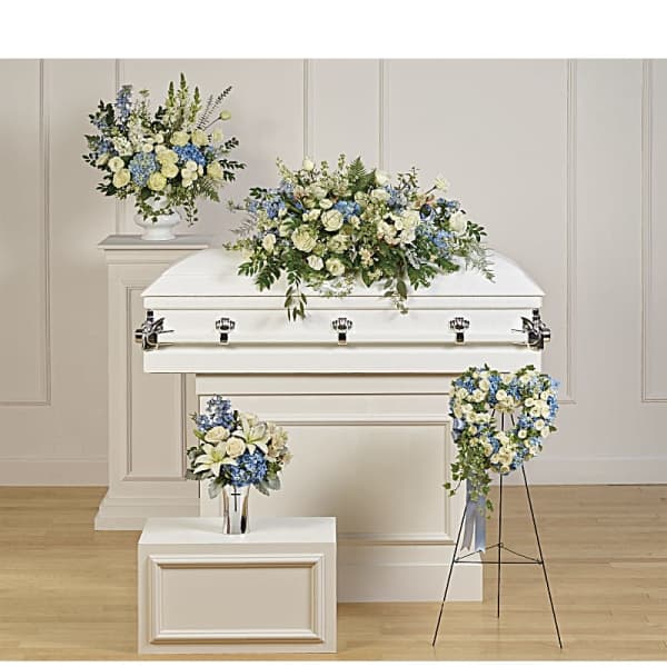 White casket with blue and white floral sprays