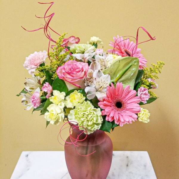 Pink and white mixed bouquet in a mauve vase