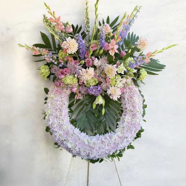Large pastel floral wreath on an easel with pink, lavender, and green blooms