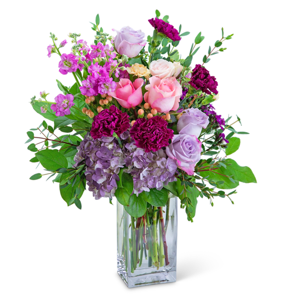 Pink and lavender roses with purple carnations in a clear glass vase