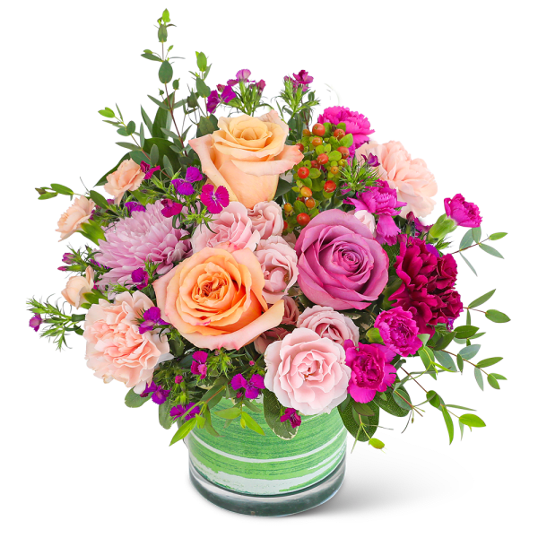 Mixed bouquet of peach, pink, and purple flowers in a green glass vase