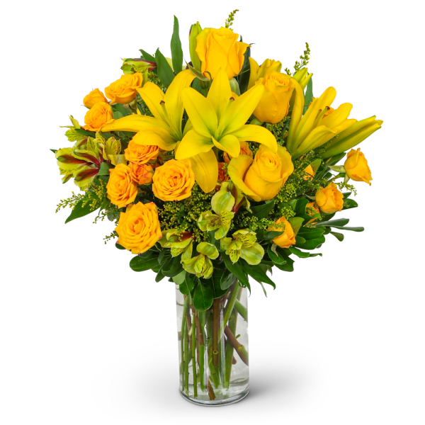Yellow roses and lilies in a clear glass vase