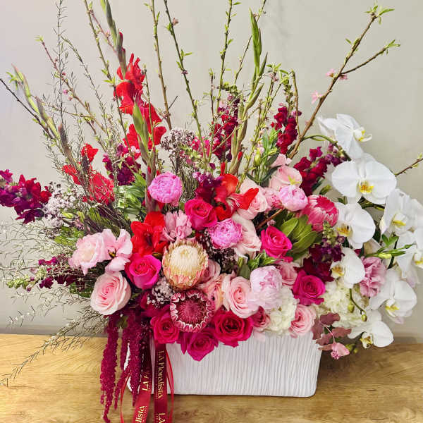 Large pink and white floral arrangement in a white container